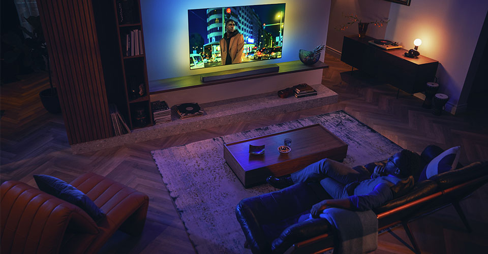 Muž si už&iacute;v&aacute; svůj Philips Ambilight TV se soundbarem
