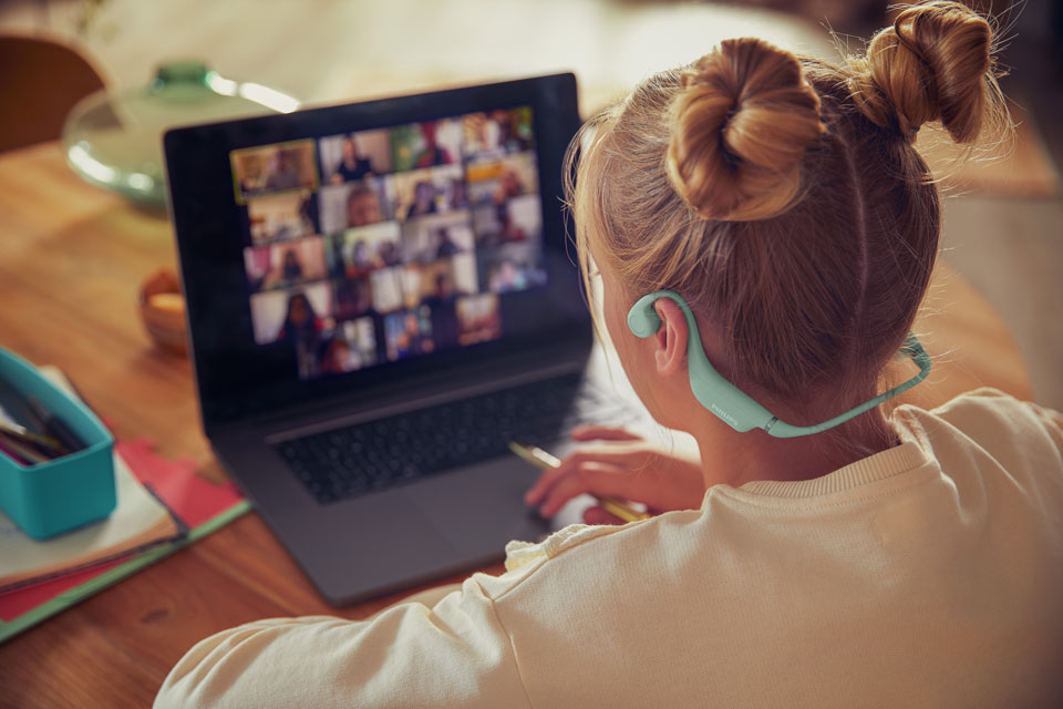 D&iacute;vka použ&iacute;vaj&iacute;c&iacute; pohodln&aacute; dětsk&aacute; sluch&aacute;tka při &scaron;koln&iacute; aktivitě.