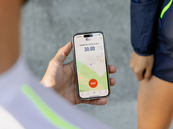 &Uacute;častn&iacute;k běhu kontroluje telefon a&nbsp;ček&aacute; na zač&aacute;tek z&aacute;vodu.