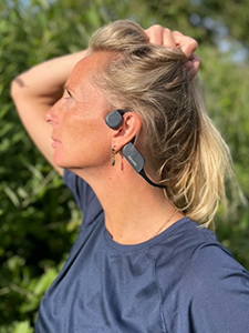 Žena se sluch&aacute;tky Bluetooth s&nbsp;kostn&iacute;m veden&iacute;m Philips